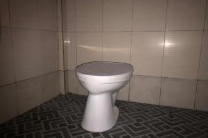 a bathroom with a white toilet in a room at Hotel O Penginapan Mc Lodge in Komodo Labuan Bajo Airport