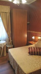 ローマにあるPetite Maisonのベッドルーム1室(大型ベッド1台、食器棚、ベッドセナルセナル付)