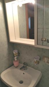a bathroom sink with a cabinet and a mirror at Petite Maison in Rome