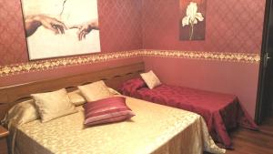 a room with two beds and a table and a bed at Petite Maison in Rome