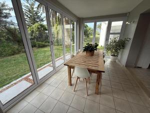 a table and chairs in a room with windows at The Tidal Court in Sea Vista