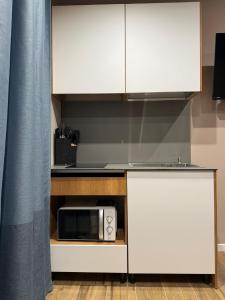 波吉邦西La Casa di Marsy的配有白色橱柜和微波炉的厨房