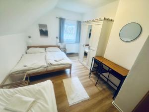 a bedroom with a bed and a table and a mirror at Chalupa Zdíkov na Šumavě in Zdíkov