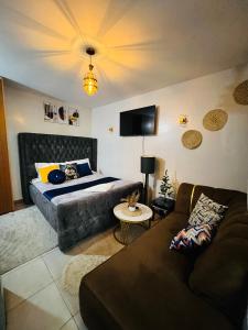 ein Wohnzimmer mit einem Bett und einer Couch in der Unterkunft adtek homes Room KIBALI in Nairobi