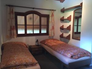 a bedroom with two beds and a window at Chalet Sunstar in Saas-Grund