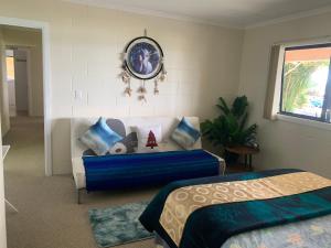 ein Schlafzimmer mit einem Bett und einem Sofa mit Kissen in der Unterkunft Seaview House Unit 2A in Whangarei