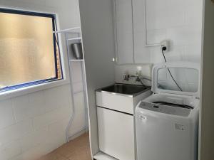 eine kleine Küche mit Spüle und Geschirrspüler in der Unterkunft Seaview House Unit 2A in Whangarei + 27 Fotos