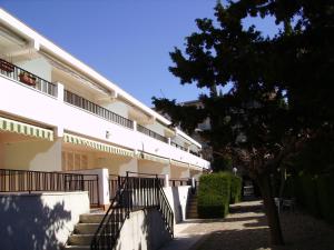 a building with stairs and a tree in front of it at Rentalmar Family Felix con parking incluido in Salou