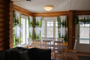 a dining room with windows and a table and chairs at Marttinen in Virrat