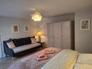 Scharrachbergheim IrmstettLe Repaire des Hirondelles - Le Colombage的带沙发和床的客厅