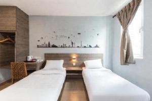 Un pat sau paturi într-o cameră la Sunlight Hotel Kulai