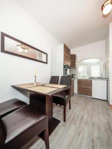 uma cozinha e sala de jantar com mesa e cadeiras em Apartments The Old Well em Gornji Vaganac