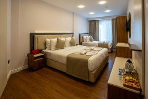 ein Hotelzimmer mit einem großen Bett und einem Schreibtisch in der Unterkunft Navoris Hotel in Istanbul