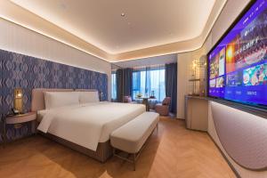 a hotel room with a bed and a flat screen tv at Manxin Hotel, Jingshi Road, Zhangqiu District, Jinan  +5 photos