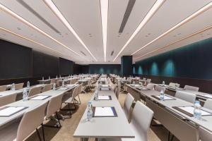 a large room with white tables and chairs at Manxin Hotel, Jingshi Road, Zhangqiu District, Jinan 