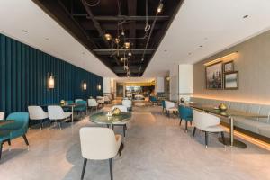 a restaurant with white chairs and tables and a green wall at Manxin Hotel, Jingshi Road, Zhangqiu District, Jinan 