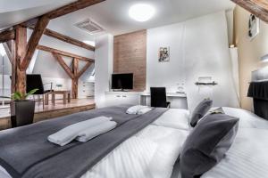 a bedroom with two white beds and a television at Pension Athanor in Český Krumlov