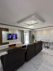 a living room with a couch and a tv on a wall at Private Room behind Out of Africa in Otjiwarongo