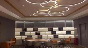 uma sala de jantar com mesas e cadeiras e um lustre em Magnotel Harbin Medical University First Affiliated Hospital em Harbin