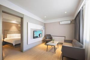 um quarto de hotel com uma cama e uma cadeira em Magnotel Harbin Medical University First Affiliated Hospital em Harbin