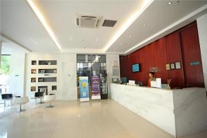 a woman standing at a counter in a lobby at City Comfort Inn Xianning Wenquan Road Walmart Plaza in Wenquanzhen