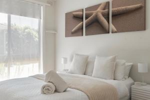 Un pat sau paturi într-o cameră la Beleura's Beachside Beauty