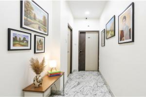 a hallway with a desk and framed pictures on the wall at Via SR Royale - Nr Sealdah Station in Kolkata