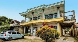 samochód zaparkowany przed domem w obiekcie Hotel O Penginapan Aina Syariah w mieście Rantaupanjang