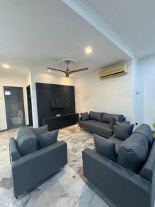 a living room with couches and a flat screen tv at Bungalow Pool Villa in Port Dickson