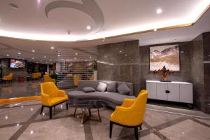 XiaoshiQingyuan Zhongkai Huafu Holiday Hotel的大厅里有沙发、椅子和桌子