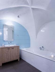 a bathroom with a tub and a sink and a mirror at Pension Athanor in Český Krumlov
