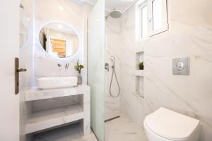 een witte badkamer met een wastafel en een toilet bij Spiros Family Apts in Laganas +42 foto's