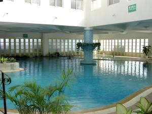 una grande piscina in un edificio con acqua blu di Kunming Dianchi Garden Hotel & Spa a Kunming
