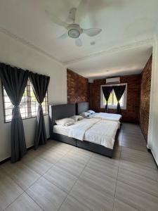 a bedroom with a bed and two windows at Bungalow Pool Villa in Port Dickson