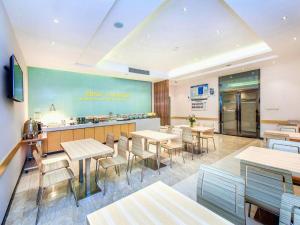 un ristorante con tavoli, sedie e un bancone di City Comfort Inn Chongqing Southwest University Beibei Metro Station a Huangjuezhen