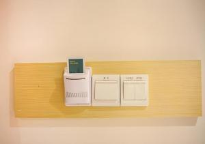 uno scaffale di legno con due elettrodomestici sopra di City Comfort Inn Nanning Jinhu Plaza Langxi Metro Station Exhibition a Nanning