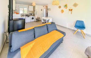 Maison Au Coeur De La Vendée في La Jonchère: غرفة معيشة مع أريكة زرقاء ومطبخ