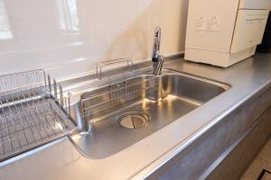 eine Küchenspüle aus Edelstahl mit einem Geschirrregal in der Unterkunft Forest and Stars Akakura Luxe in Myōkō + 53 Fotos