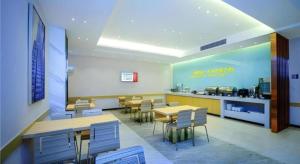 un ristorante con tavoli e sedie in una stanza di City Comfort Inn Chongqing Southwest University Beibei Metro Station a Huangjuezhen