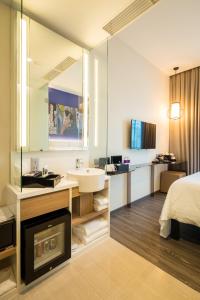 a hotel bathroom with a sink and a mirror at Mercure Singapore Bugis in Singapore