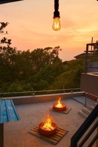 two fires on a patio with the sunset in the background at Wildcrest Homestay in Madikeri