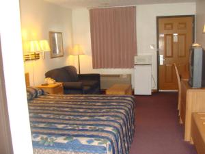 a hotel room with a bed and a television at USA Inns of America in Doniphan