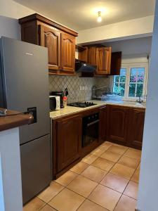 圣皮埃尔Villa Corbeil的厨房配有木制橱柜和不锈钢冰箱