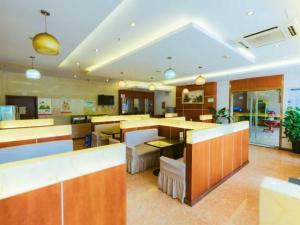 una grande cucina con ripiani e tavoli in legno di GreenTree Inn Jiaxing Zhongan Business Hotel a Jiaxing