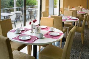a table and chairs in a restaurant with a table and chairs at Blue Sea Hotel Alimos in Athens