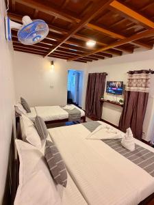 a room with three beds in a room at Wildcrest Homestay in Madikeri