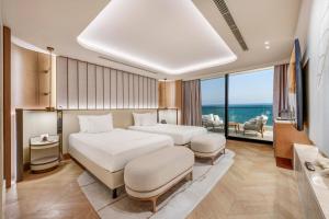 a bedroom with two beds and a view of the ocean at Regnum The Crown in Belek +89 photos