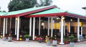 达瓦拉维Sihilro Regency Hotel的楼前有植物的餐厅