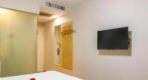 乌鲁木齐7 Days Inn Urumqi Guangming Road Beimen Metro Station的墙上配有平面电视的房间