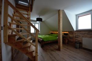 ein Schlafzimmer mit einem grünen Bett und einer Treppe in der Unterkunft Apartmány Benecko 155 in Benecko